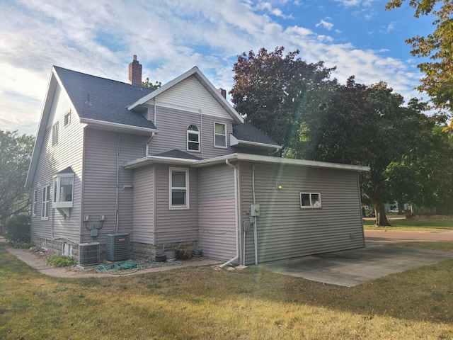 view of side of home with a yard, a patio, and cooling unit