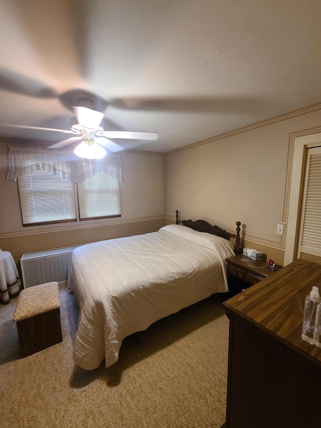 carpeted bedroom with ceiling fan and radiator heating unit