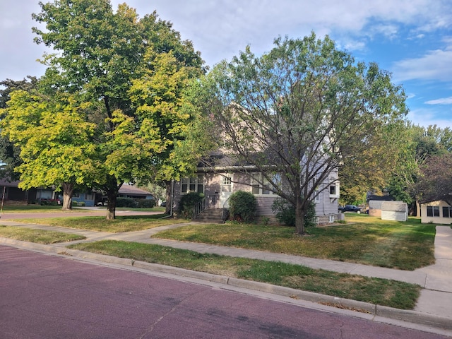 view of property hidden behind natural elements featuring a front yard