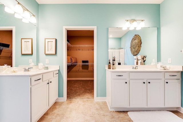 full bathroom featuring a stall shower, a spacious closet, and two vanities