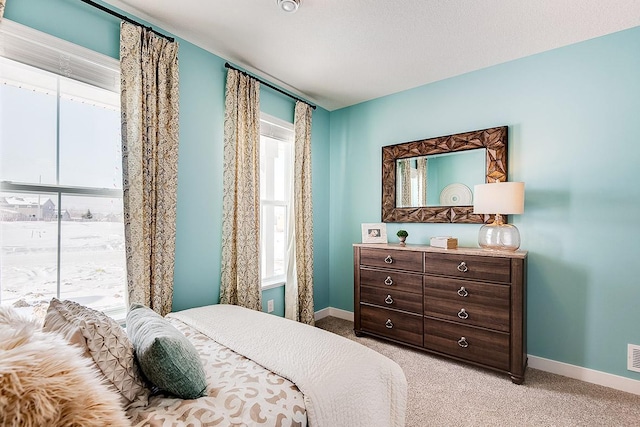 bedroom featuring baseboards and light colored carpet