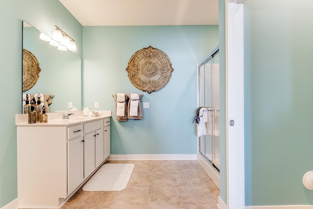 full bathroom featuring baseboards, a shower stall, and vanity