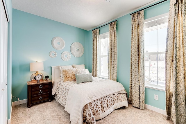 carpeted bedroom with baseboards and multiple windows