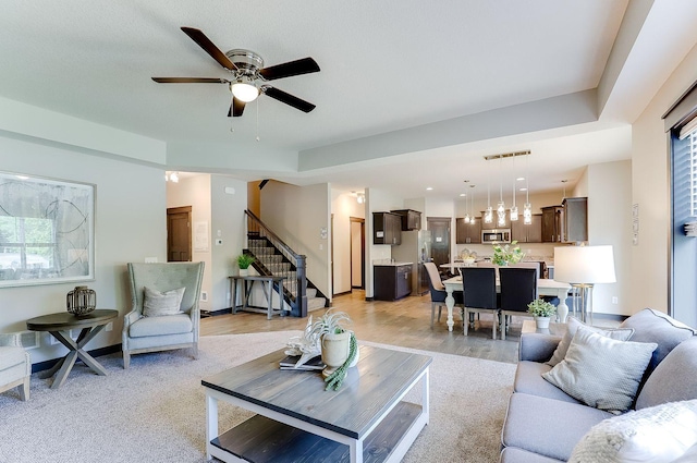 living room with ceiling fan and light hardwood / wood-style floors