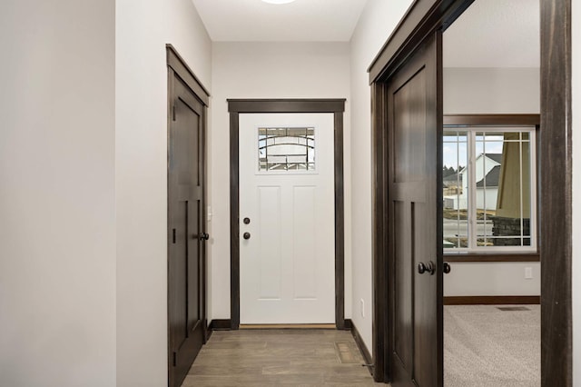 entryway with light wood-style flooring, visible vents, and baseboards