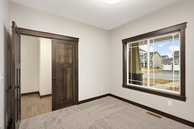 unfurnished bedroom featuring baseboards, visible vents, and carpet flooring