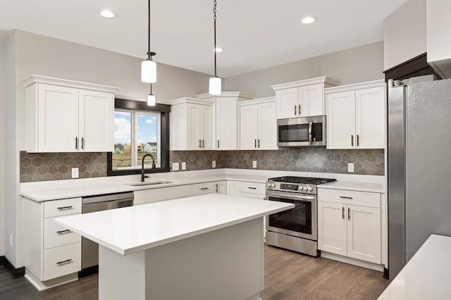 kitchen with stainless steel appliances, dark wood-style flooring, a sink, and light countertops