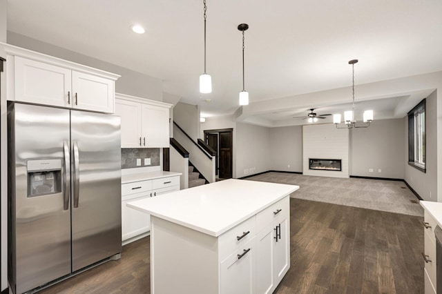 kitchen featuring light countertops, a glass covered fireplace, white cabinetry, and stainless steel fridge with ice dispenser