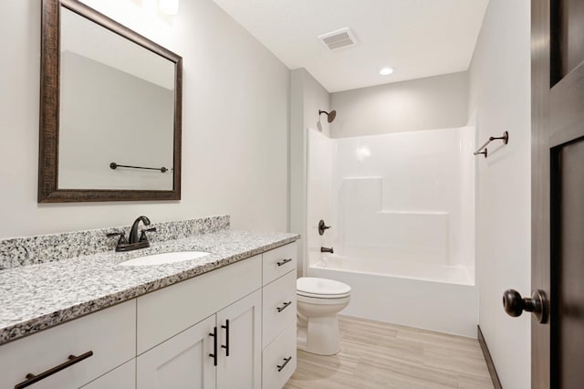 full bathroom featuring visible vents, toilet, vanity, wood finished floors, and  shower combination