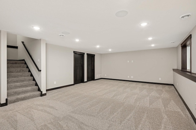 finished below grade area featuring light carpet, recessed lighting, and baseboards