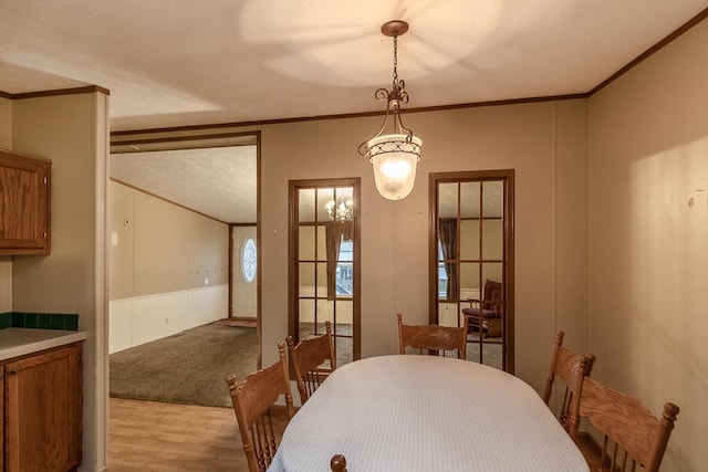 dining space with light hardwood / wood-style floors and ornamental molding