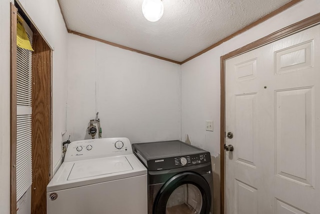 washroom featuring washer and dryer, ornamental molding, and a textured ceiling