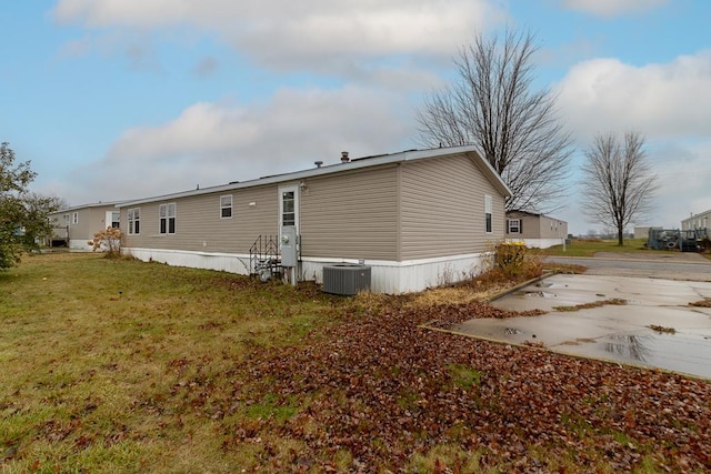 rear view of house with a yard and central AC unit