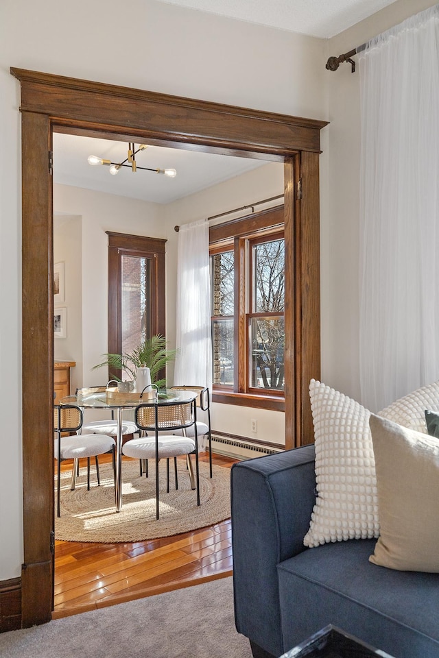 dining room with an inviting chandelier, carpet floors, and baseboard heating