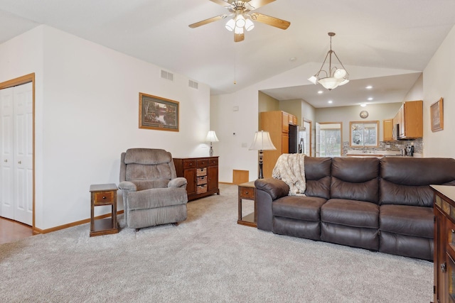 carpeted living room with ceiling fan and lofted ceiling