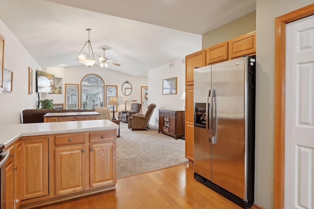 kitchen featuring appliances with stainless steel finishes, light wood-type flooring, ceiling fan with notable chandelier, vaulted ceiling, and pendant lighting