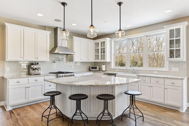21360 Christmas Ln, Shorewood, MN 55331 - kitchen with wall chimney range hood, tasteful backsplash, white cabinetry, and a sink