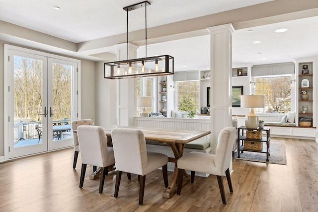 21360 Christmas Ln, Shorewood, MN 55331 - dining space featuring french doors, decorative columns, wood finished floors, and a healthy amount of sunlight