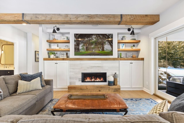 21360 Christmas Ln, Shorewood, MN 55331 - living room featuring light wood-style floors, built in features, beamed ceiling, and a tiled fireplace