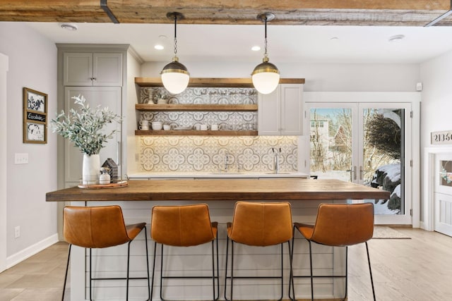 21360 Christmas Ln, Shorewood, MN 55331 - bar featuring pendant lighting, a sink, backsplash, and baseboards