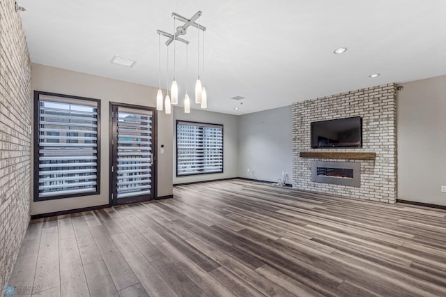 unfurnished living room with wood-type flooring and an inviting chandelier