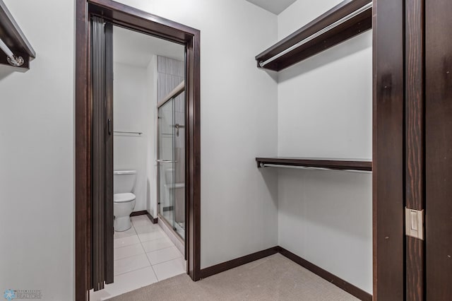 walk in closet with light tile patterned floors