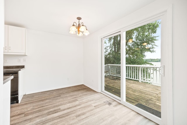 unfurnished dining area featuring a chandelier, baseboards, a healthy amount of sunlight, and light wood finished floors