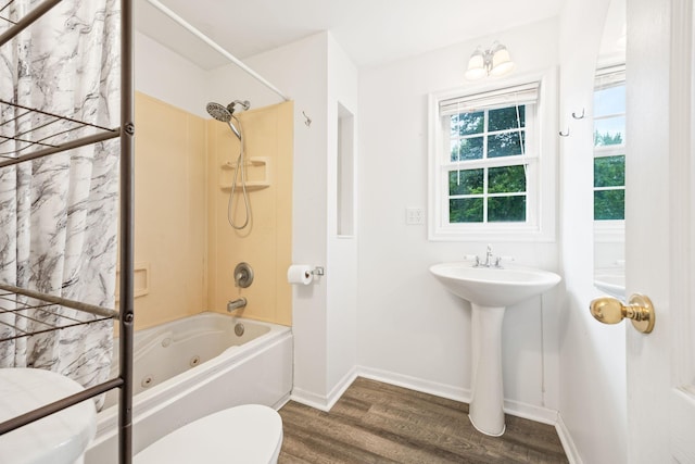 bathroom with toilet, bathing tub / shower combination, baseboards, and wood finished floors