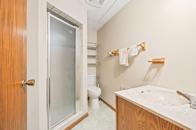 full bathroom featuring vanity, a shower stall, toilet, and baseboards