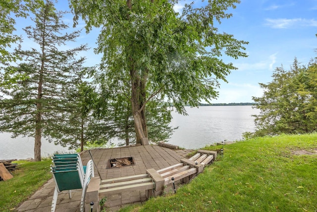 exterior space with a water view and a fire pit