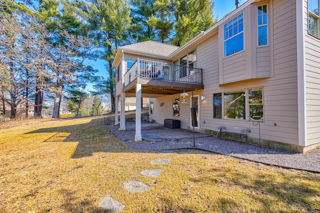 rear view of property featuring a yard, a patio, and a wooden deck