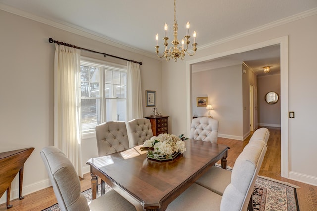 dining area with an inviting chandelier, crown molding, light wood-type flooring, and baseboards