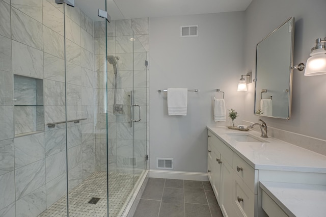 bathroom with visible vents, a stall shower, vanity, and baseboards