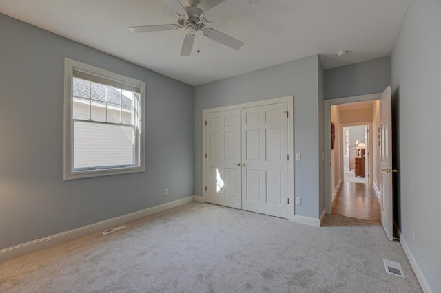 unfurnished bedroom with carpet, visible vents, and baseboards