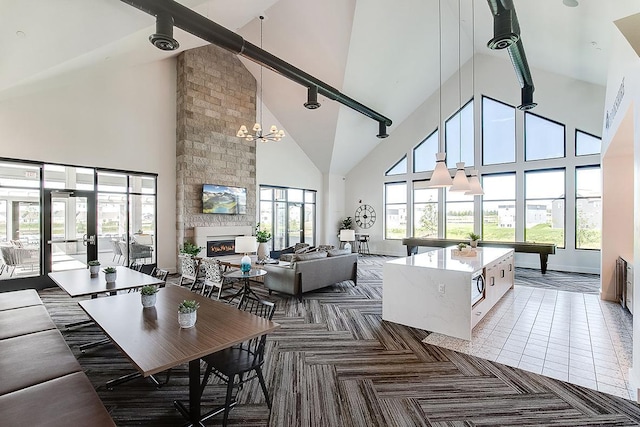 carpeted living room featuring beam ceiling, an inviting chandelier, high vaulted ceiling, a fireplace, and pool table