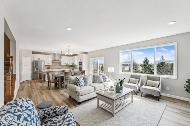 living room with a chandelier and light hardwood / wood-style flooring