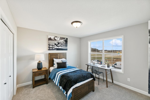 bedroom featuring light colored carpet and a closet