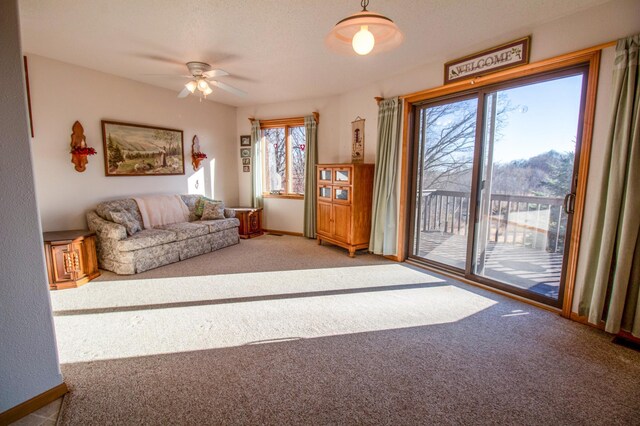 unfurnished living room featuring ceiling fan, a healthy amount of sunlight, and carpet floors