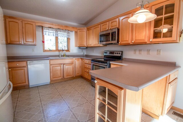 kitchen featuring kitchen peninsula, stainless steel appliances, vaulted ceiling, sink, and hanging light fixtures