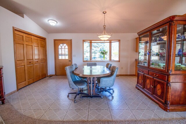 tiled dining space with vaulted ceiling