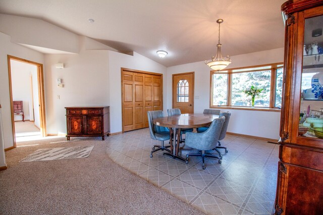 carpeted dining room featuring lofted ceiling