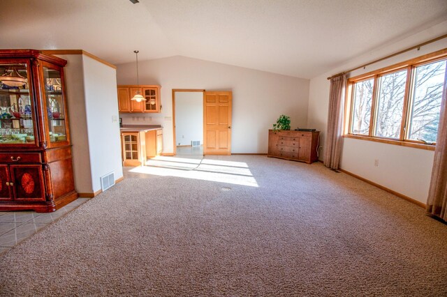 unfurnished living room with light carpet and vaulted ceiling