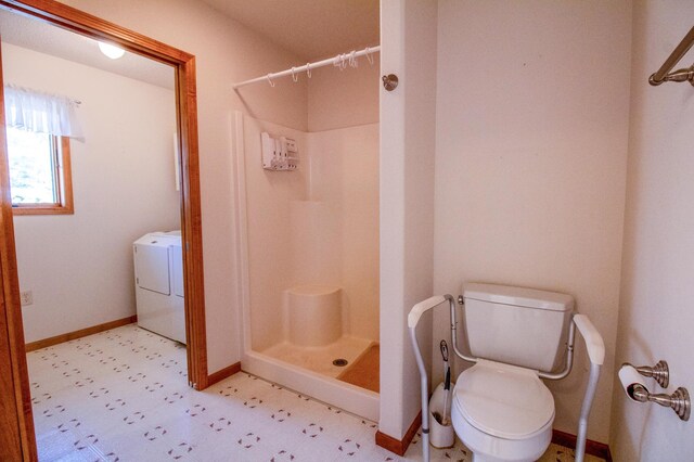 bathroom with toilet, a shower, and washer / clothes dryer