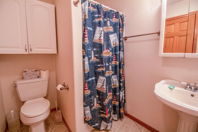 bathroom featuring a shower with curtain, toilet, tile patterned floors, and sink