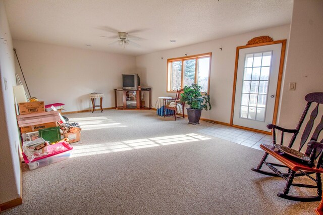 playroom with a textured ceiling, ceiling fan, and light carpet