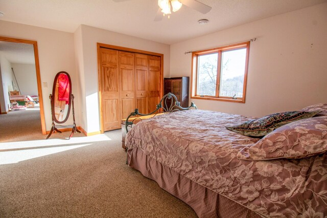 carpeted bedroom featuring ceiling fan and a closet