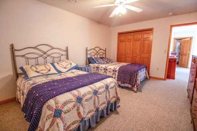 carpeted bedroom featuring ceiling fan and a closet