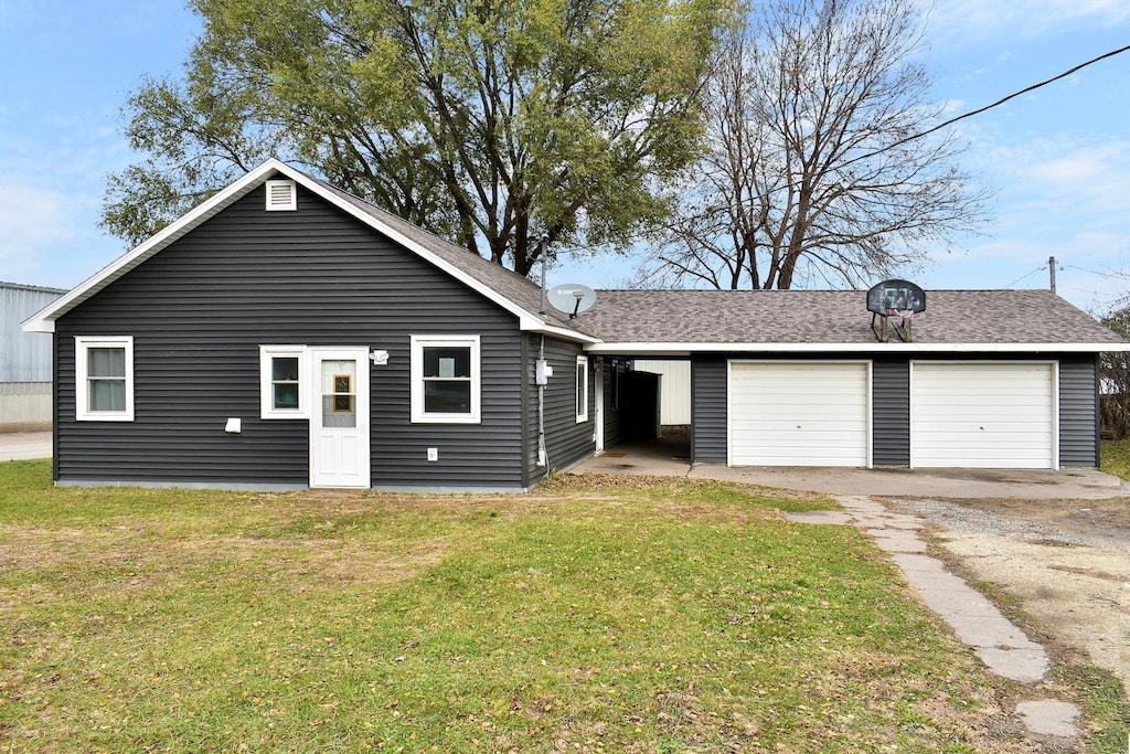 ranch-style home with a garage and a front lawn