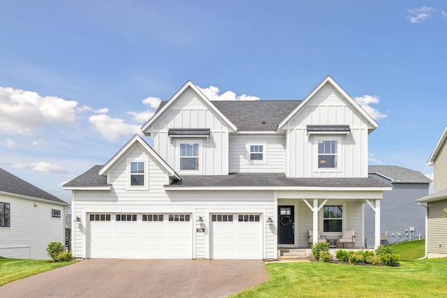 view of front of home featuring a porch, a garage, driveway, a front lawn, and board and batten siding