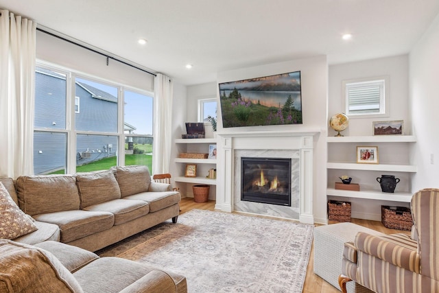 living area featuring light wood-style floors, a fireplace, and recessed lighting